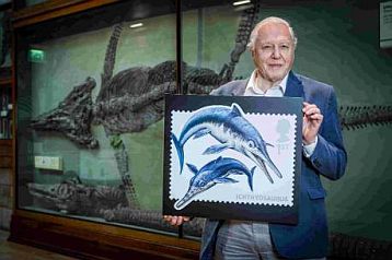 Sir David Attenborough with dinosaur stamp from UK 2013
